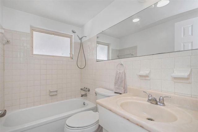 full bathroom featuring tile walls, tiled shower / bath, vanity, and toilet