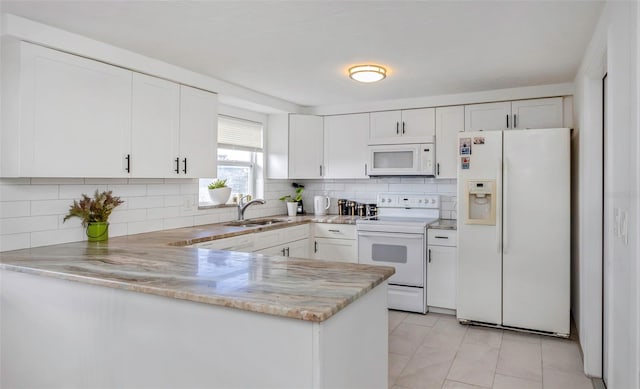 kitchen featuring white cabinetry, sink, white appliances, and kitchen peninsula