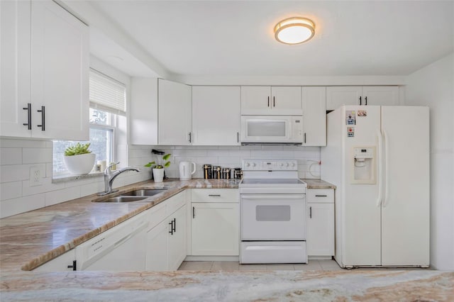 kitchen with sink, white cabinetry, tasteful backsplash, light stone counters, and white appliances