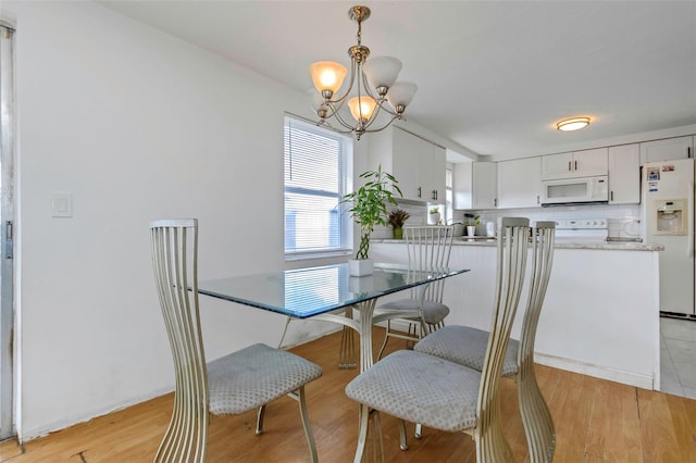 dining room with a notable chandelier and light wood-type flooring