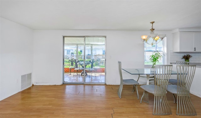 dining area featuring a wealth of natural light, a notable chandelier, and light hardwood / wood-style floors