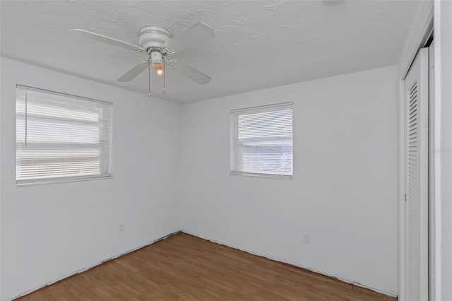 unfurnished bedroom with hardwood / wood-style floors, a closet, and ceiling fan