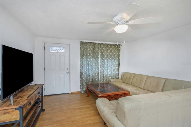 living room featuring a textured ceiling, ceiling fan, and light hardwood / wood-style flooring