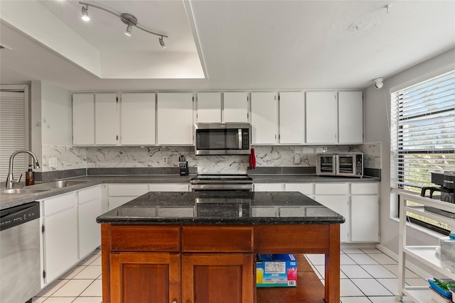 kitchen featuring sink, a tray ceiling, stainless steel appliances, and white cabinets