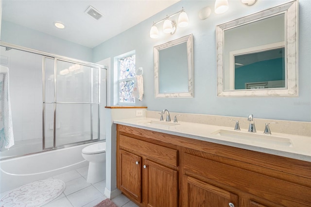 full bathroom with tile patterned flooring, vanity, enclosed tub / shower combo, and toilet