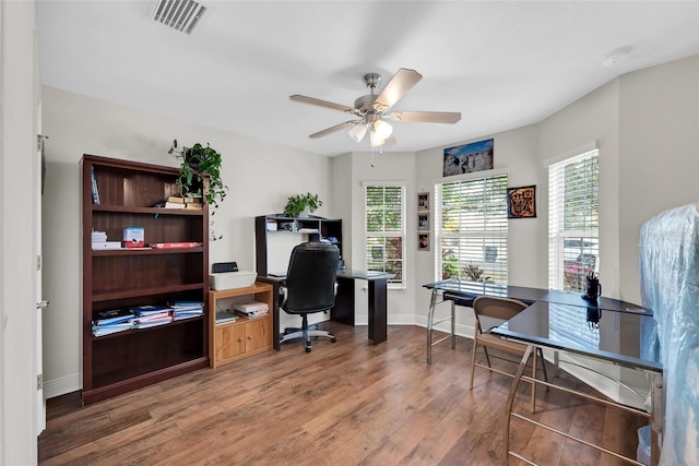 office featuring baseboards, ceiling fan, visible vents, and wood finished floors