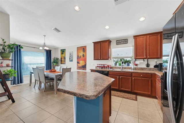 kitchen featuring a center island, light tile patterned floors, visible vents, a sink, and black appliances