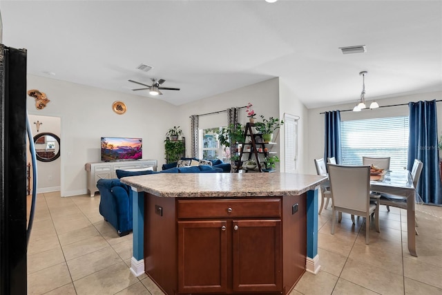 kitchen featuring pendant lighting, visible vents, open floor plan, and a center island