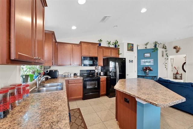 kitchen featuring visible vents, a kitchen island, open floor plan, black appliances, and a sink