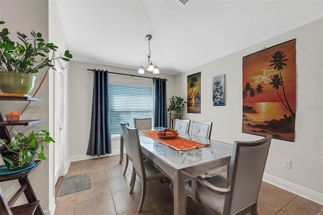 dining area with tile patterned flooring, baseboards, and an inviting chandelier