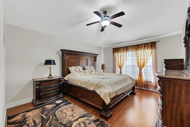 bedroom with ceiling fan, dark wood finished floors, and baseboards