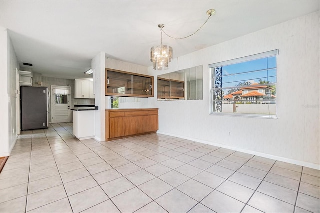 kitchen with decorative light fixtures, stainless steel fridge, a chandelier, and a wealth of natural light