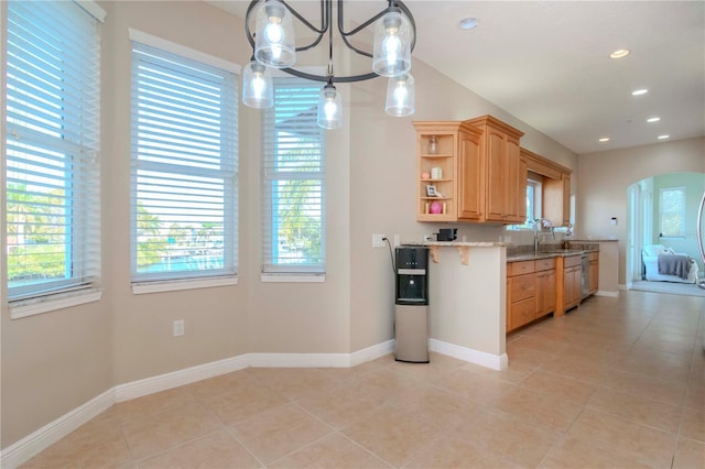 kitchen with light tile patterned floors, decorative light fixtures, plenty of natural light, and light stone countertops