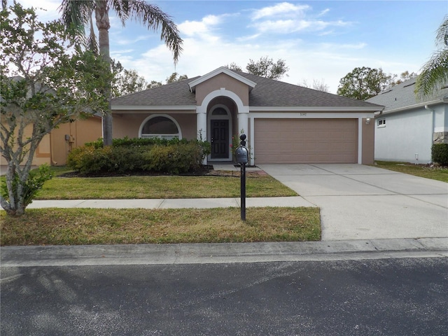 single story home featuring a garage and a front yard