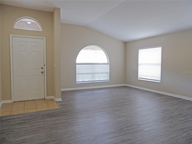 foyer entrance with dark hardwood / wood-style flooring and vaulted ceiling