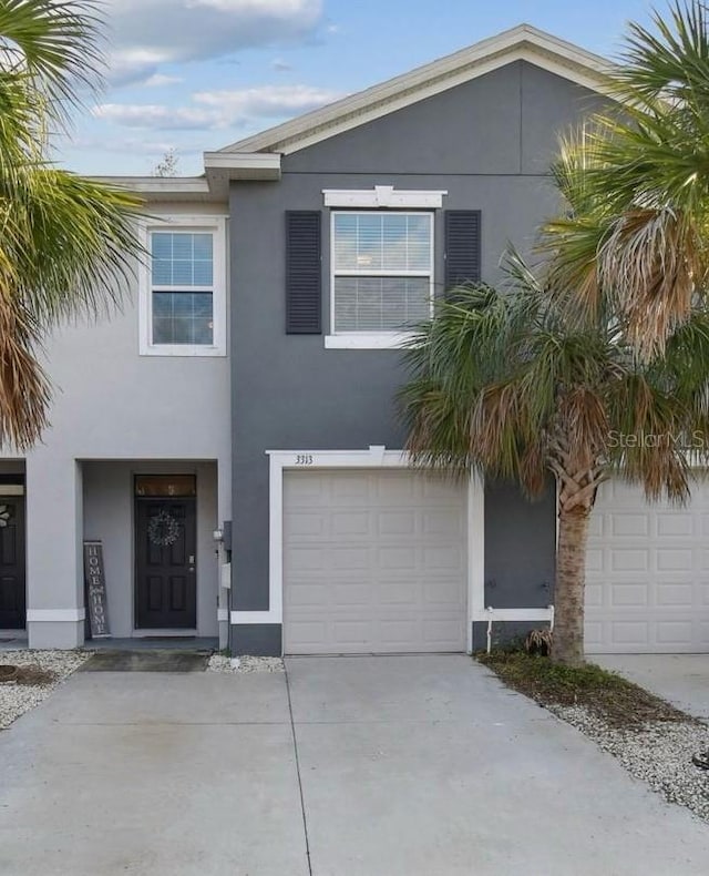 view of front of home featuring stucco siding, an attached garage, and concrete driveway