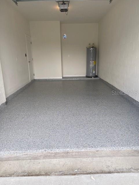 garage featuring electric water heater and a garage door opener