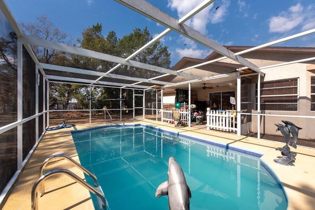 view of pool featuring a patio area, ceiling fan, and glass enclosure