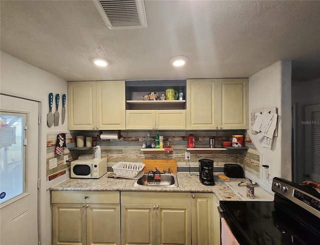 kitchen featuring electric stove, sink, light stone countertops, and a textured ceiling