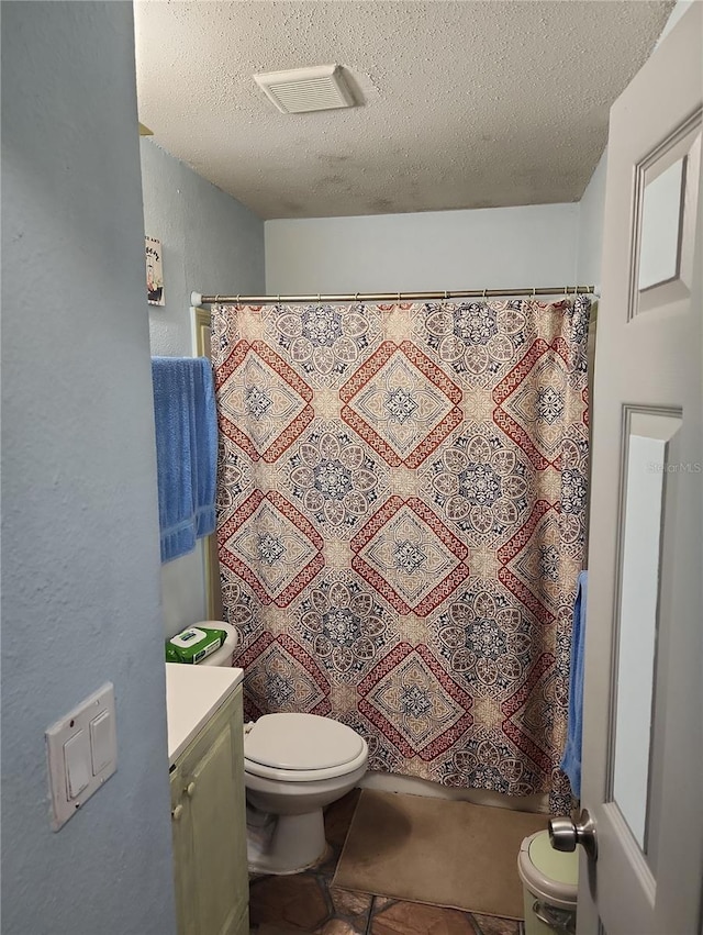 bathroom with tile patterned flooring, curtained shower, toilet, a textured ceiling, and vanity