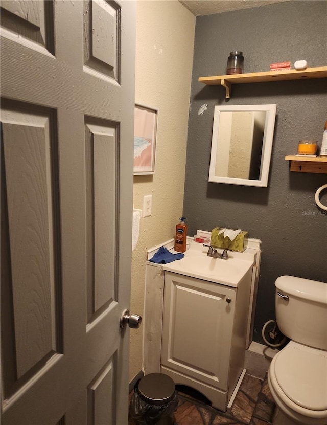 bathroom featuring toilet and vanity