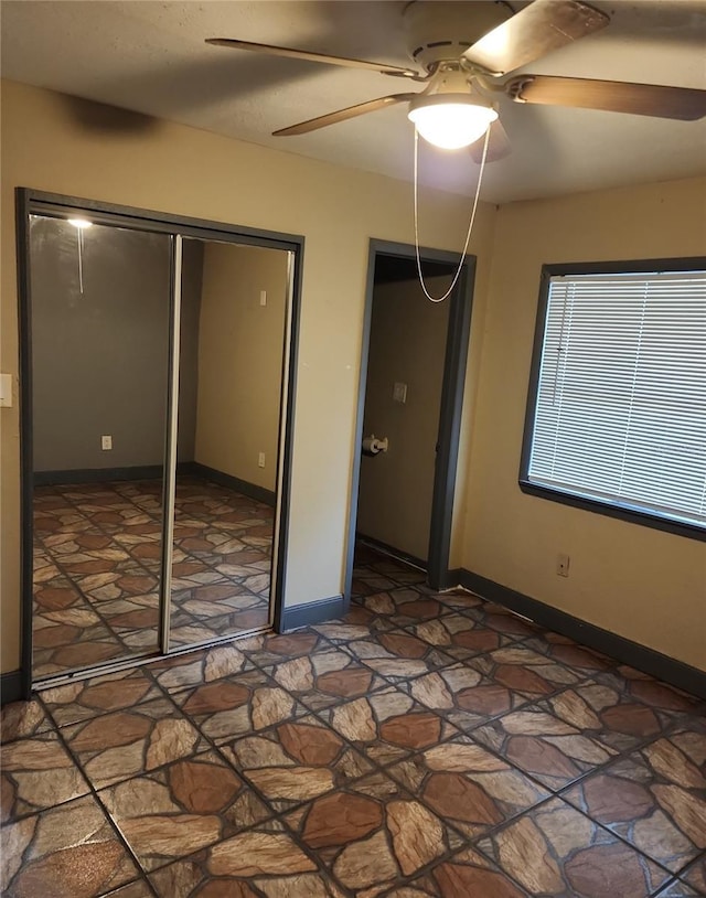6328 W Park Dr, Homosassa, FL 34446 - unfurnished bedroom featuring a closet, baseboards, a ceiling fan, and stone finish floor