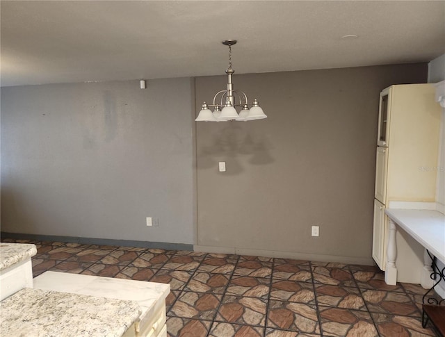 6328 W Park Dr, Homosassa, FL 34446 - unfurnished dining area with baseboards, an inviting chandelier, and stone finish flooring