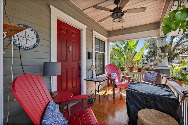 wooden terrace with ceiling fan and covered porch