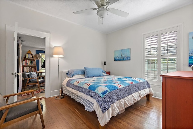 bedroom with wood-type flooring, ceiling fan, and a textured ceiling