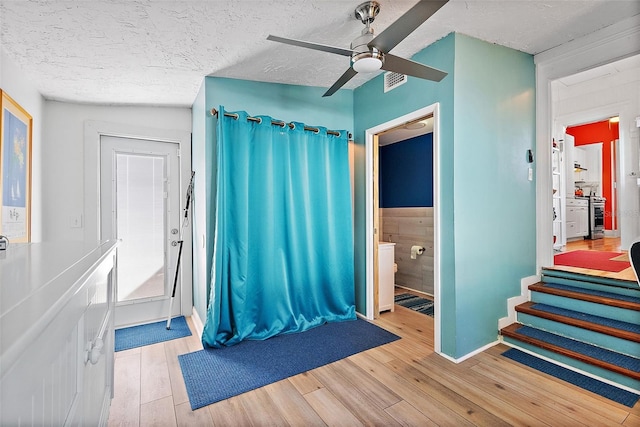 bathroom featuring hardwood / wood-style flooring, ceiling fan, a textured ceiling, and toilet