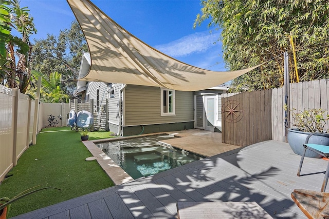 rear view of house featuring a swimming pool side deck and a lawn