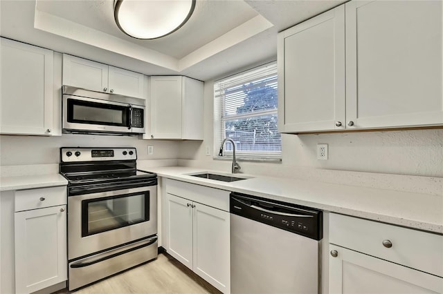 kitchen featuring appliances with stainless steel finishes, sink, and white cabinets