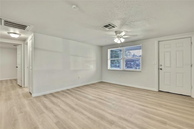 empty room with ceiling fan, a textured ceiling, and light hardwood / wood-style flooring