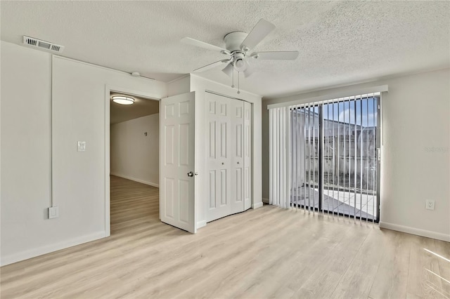 unfurnished bedroom with ceiling fan, light hardwood / wood-style floors, and a textured ceiling