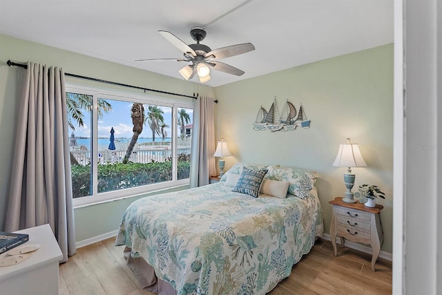 bedroom featuring a ceiling fan, baseboards, and light wood finished floors