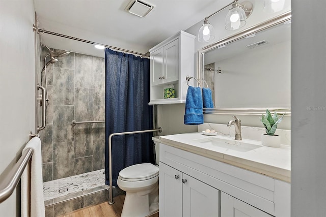 bathroom featuring visible vents, vanity, toilet, and a shower stall