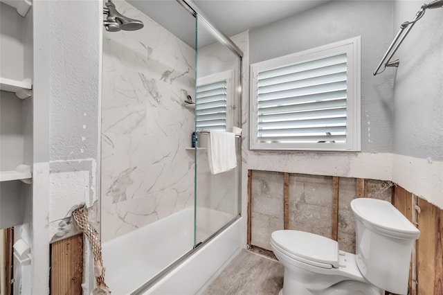 bathroom featuring shower / bath combination with glass door and toilet