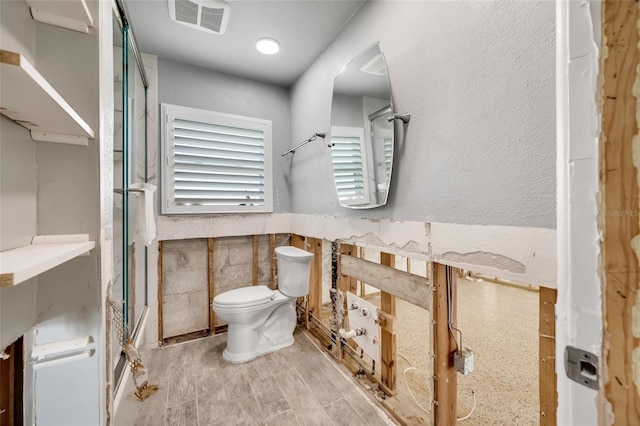 bathroom with hardwood / wood-style flooring and toilet