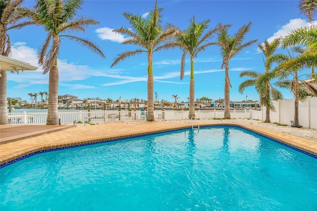 view of swimming pool with a fenced in pool, a fenced backyard, and a water view