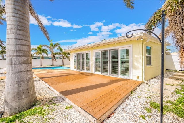 exterior space with a fenced in pool, a fenced backyard, and a deck