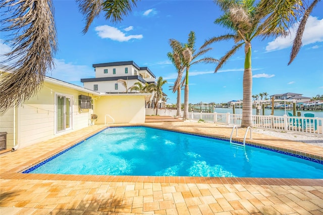 view of pool with a water view, fence, a patio area, and a fenced in pool