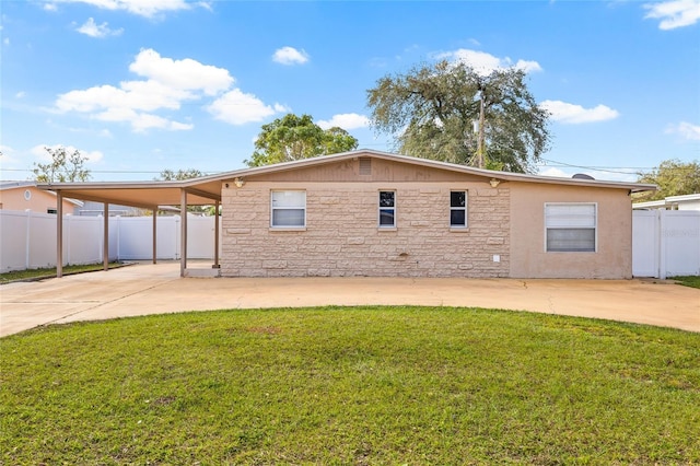 back of house featuring a yard and a carport