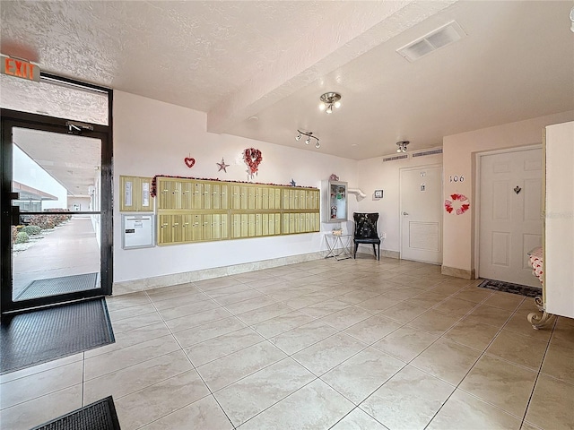 8174 Terrace Garden Dr N Unit 307, Saint Petersburg, FL 33709 - interior space featuring light tile patterned floors, mail boxes, and a textured ceiling