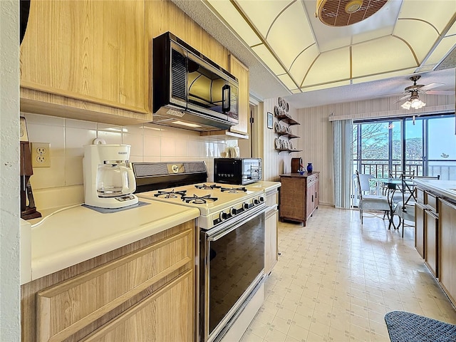 8174 Terrace Garden Dr N Unit 307, Saint Petersburg, FL 33709 - kitchen featuring ceiling fan, decorative backsplash, and white range with gas stovetop