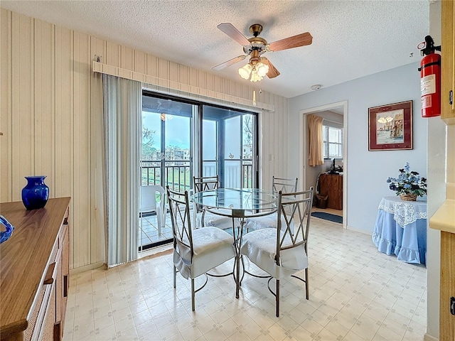 8174 Terrace Garden Dr N Unit 307, Saint Petersburg, FL 33709 - dining room featuring ceiling fan, a textured ceiling, and wood walls