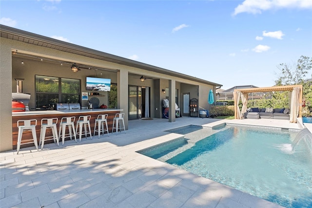 view of swimming pool with ceiling fan, a patio, outdoor dry bar, and an outdoor hangout area