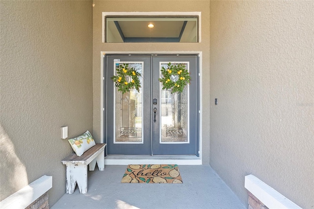 doorway to property featuring french doors and stucco siding