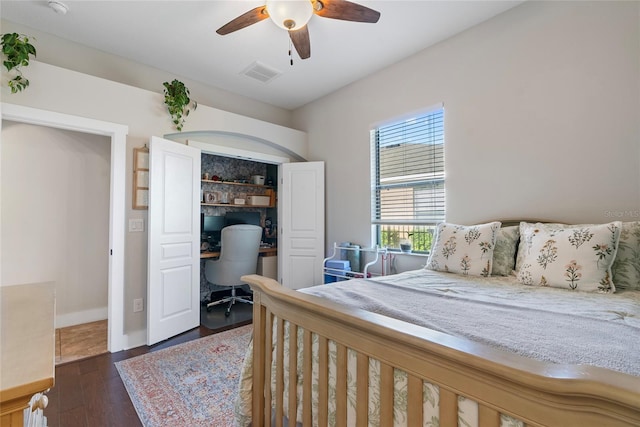 bedroom featuring a closet, dark wood-style flooring, visible vents, and a ceiling fan