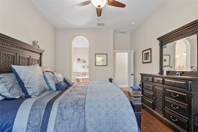 bedroom with visible vents, connected bathroom, arched walkways, and dark wood-style flooring