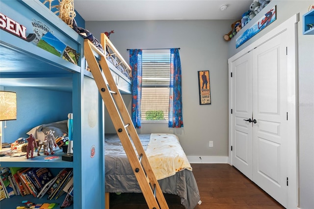 bedroom featuring a closet, baseboards, and wood finished floors